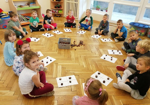 zdjęcie z przodu na wszystkie dzieci siedzące na podłodze w kole