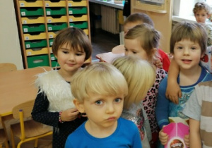 dzieci stoją przy dziewczynce z cukierkami