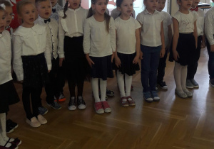 Dzieci stoją na baczność i śpiewają hymn