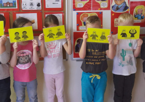 Dzieci trzymają kartki ze znakami migowymi