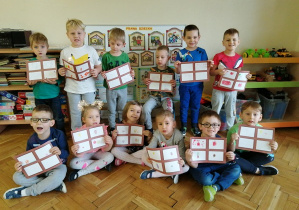 dzieci stoją w grupie i polazują swoje prace