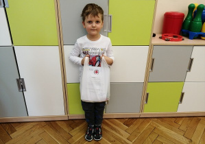 chłopiec pozuje do zdjęcia trzymając torbę z nagrodami