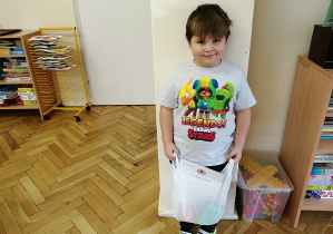 chłopiec pozuje do zdjęcia z nagrodami