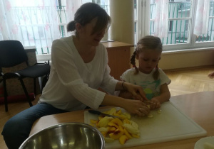 Pani pomaga kroić dziewczynce banana