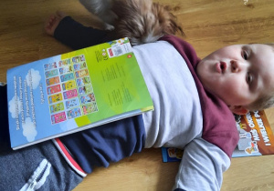 chłopiec oddycha z książką na brzuchu
