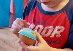chłopiec maluje jajka