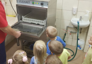 Dzieci zaglądają do wyparzarki w kuchni