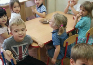 Dzieci przy stoliku próbują bułeczek 