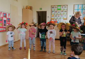 Dzieci stoją w kolorowych kapeluszach
