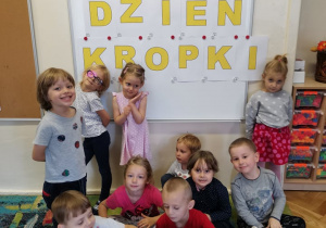 Dzieci przy tablicy z pracą w kropki.