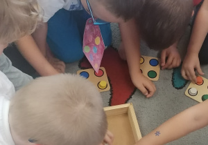 Dzieci układają drewniana układankę z kropek
