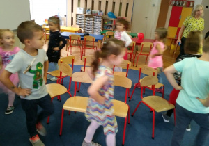 Dzieci bawią się wspólnie w zabawę z krzesełkami.