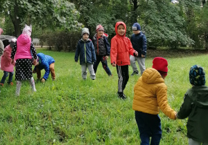 Dzieci biegają po trawie w parku