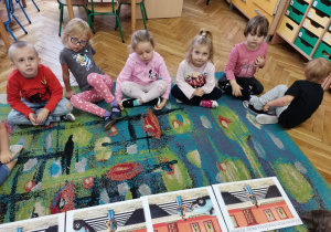 Dzieci pracują na dywanie z obrazkami