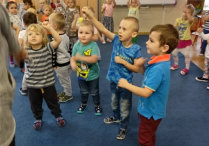 Dzieci tańczą w kole według instrukcji nauczyciela