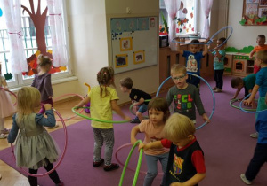 Dzieci z hula - hop ćwiczą na zajęciach ruchowych