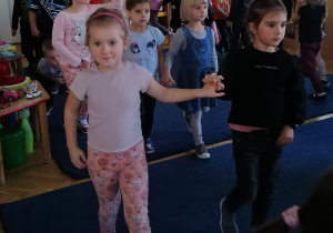 Dzieci tańczą w parach według instrukcji pani