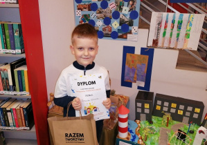 Chłopiec z wyróżnieniem pokazuje swoją prace